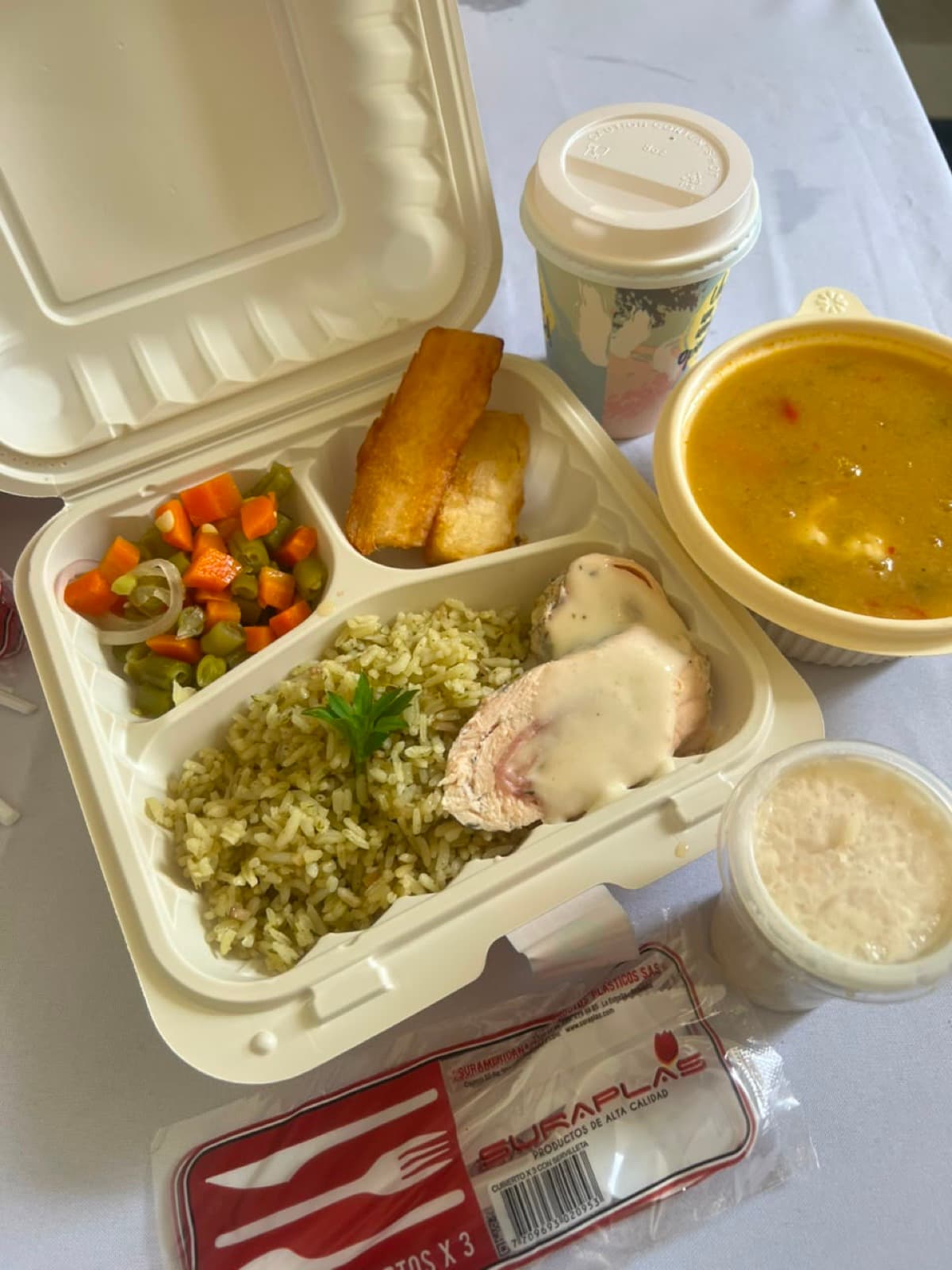 Almuerzo empresarial empacado con arroz, pollo en salsa, verduras, sopa y postre — alimentación corporativa de Aura Sabor en Ibagué